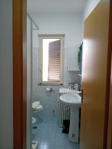 a bathroom with a sink and a toilet and a window at Marica House Spiaggia Coreca Amantea in Amantea +15 photos