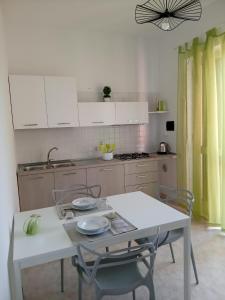 a kitchen with a white table and chairs and a table at Marica House Spiaggia Coreca Amantea in Amantea