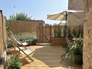 a patio with two chairs and an umbrella at Estudio Niu Lohodihomes in Girona