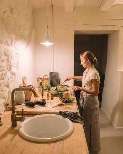 a woman standing in a kitchen next to a sink at Estudio Niu Lohodihomes in Girona +26 photos