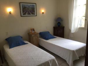 a bedroom with two beds and a picture on the wall at Maison avec piscine privative Taillades Luberon LS2-281 in Les Taillades +21 photos