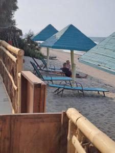 a group of chairs and umbrellas on a beach at H0TELIER Home, Máncora in Máncora