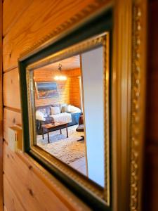 espejo reflejo de una sala de estar con sofá en Authentic Arctic Villa at the Delta, en Rovaniemi