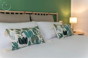 a bed with pillows on it with acknowled at Marina Verde in Borgio Verezzi