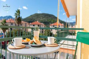 a table with bread and coffee cups on a balcony at Marina Verde in Borgio Verezzi