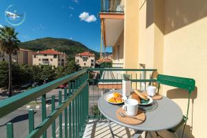 a table with a plate of food on a balcony at Marina Verde in Borgio Verezzi