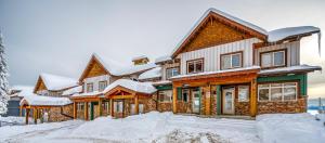 ビッグ・ホワイトにあるVista at Big White w Amazing Location and Viewの屋根に雪が積もった木造家屋