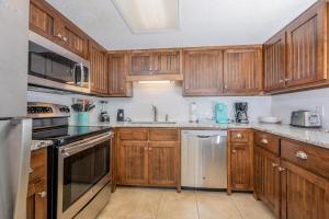 a kitchen with wooden cabinets and stainless steel appliances at Phoenix VI 6312 in Orange Beach