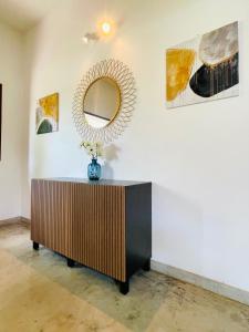 a mirror on a wall with a dresser in a room at Six Boutique Collection in Mannārgudi