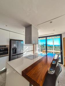 a large kitchen with a wooden table and a counter top at Villa Símera in Laganas