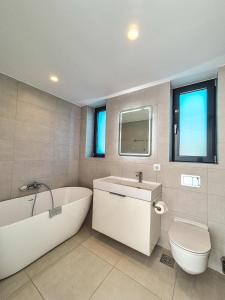 a bathroom with a tub and a toilet and a sink at Villa Símera in Laganas +11 photos