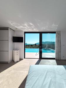 a bedroom with a bed and a view of a pool at Villa Símera in Laganas