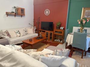a living room with couches and a tv at Cozy Place living in Kozani