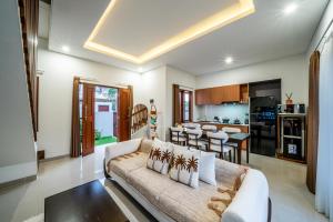 a living room with a couch and a kitchen at Promo!! New Rosa Villa Muding, Luxury and cozy 3Bedrooms Villa in Heart of Kerobokan with Special Office Room in Kerobokan