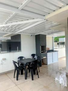 a dining room with a table and chairs in a kitchen at Triplex em Caraguatatuba! Alto padrão in Caraguatatuba