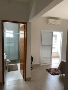 a room with a glass door leading to a bathroom at Triplex em Caraguatatuba! Alto padrão in Caraguatatuba