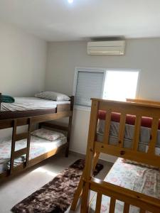 a room with two bunk beds and a window at Triplex em Caraguatatuba! Alto padrão in Caraguatatuba