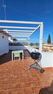a grill and a table on a patio at El Fortín de la playa by Sanlúcar Housing in Sanlúcar de Barrameda