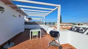 a patio with a grill and a table on a balcony at El Fortín de la playa by Sanlúcar Housing in Sanlúcar de Barrameda