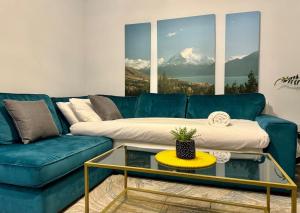 伯明翰Last-Minute Secure l Reserve Now l Sleeps Up to 3 l 262 Bradford Street , Birmingham l Cozy City Centre Stay l JVT Short Lets的客厅里有一张蓝色沙发和一张玻璃桌
