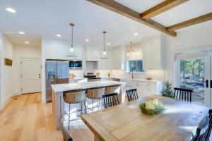 a kitchen with white cabinets and a wooden table at Mountain Home with Private Hot Tub and River Access! in Bend