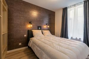 une chambre avec un grand lit et une fenêtre dans l'établissement Charmant appartement au cœur du quartier historique des Allemands, à Metz