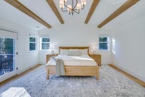 a bedroom with a bed and a chandelier at Mountain Home with Private Hot Tub and River Access! in Bend