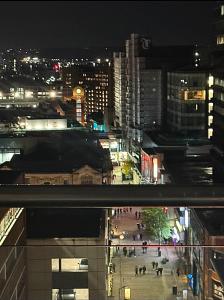 a city at night with people walking on a street at Award Winner of 2026 &2025 traveller & Best guest rated apartment, two bedroom, #1 Leeds city centres most central location, Great 180 degree views,balcony , PARKING onsite, Netflix & WiFi in Leeds