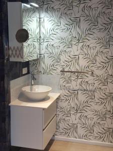 ein Badezimmer mit Waschbecken und Blättertapete in der Unterkunft Waregem Hotel A in Waregem + 106 Fotos