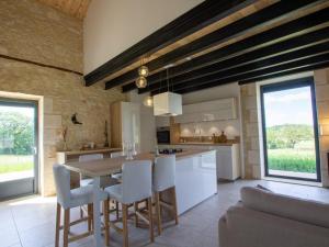 a kitchen with a wooden table and white chairs at Maison climatisée avec terrasse et Wi-Fi, animaux admis, proche Périgord Vert - FR-1-616-391 in Sorges