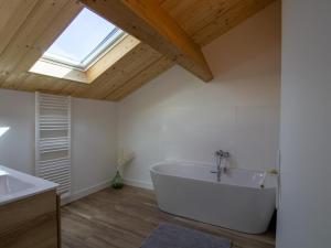a large white bath tub in a bathroom with a skylight at Maison climatisée avec terrasse et Wi-Fi, animaux admis, proche Périgord Vert - FR-1-616-391 in Sorges