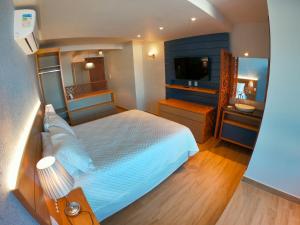a bedroom with a large bed and a bathroom at Pousada Gamboa estações in Garopaba +44 photos
