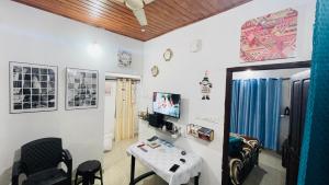 a room with a table and chairs and a tv at Munnar Hills And Mist Views in Anachal