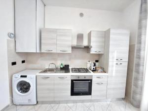 a kitchen with white cabinets and a washing machine at A due passi dal Centro Intero appartamento con AC e WiFi in Forlì +3 photos