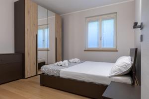 ムッソにあるApartment Tita - Mussoの白いシーツと鏡が付いたベッドのある寝室