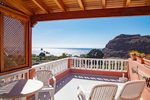 a balcony with a table and chairs and the ocean at Apartamentos Bellavista Gomera in Playa de Santiago