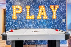 a ping pong table with a sign that reads play at 35 Hideaway - Mtn Views, Hot Tub, Game Room, Dogs Ok, 12 Mins to Sunday River in Bethel