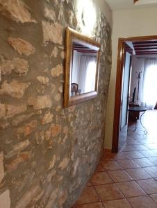 a mirror on a stone wall in a room at Ca L'Aida Rural 2 in Montblanc