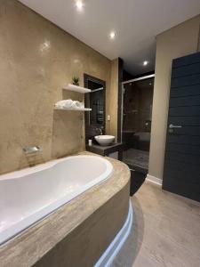 a large bathroom with a tub and a toilet at Central Cape Town Apt with Views in Cape Town