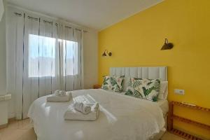 une chambre avec un grand lit blanc avec des serviettes dessus dans l'établissement Apartamento El Nido, à Torre del Mar