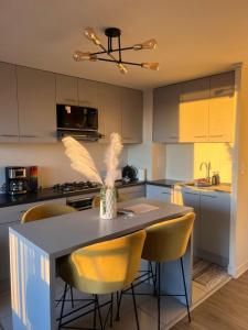 a kitchen with a table and some yellow chairs at Depto Residencial Guardia24 Hrs in Puerto Montt