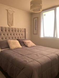 a bedroom with a large bed with a large window at Depto Residencial Guardia24 Hrs in Puerto Montt +14 photos
