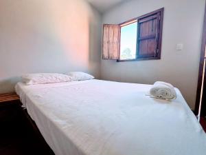 a bedroom with a large white bed with a window at Santa Clara Hotel & Tours in Santa Clara
