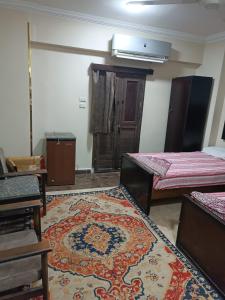 a room with two beds and a rug on the floor at فندق الإيمان El Eman Hotel in Maḩaţţat Idfū