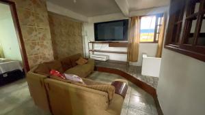a living room with a couch and a tv at Pousada da Praia Frade in Angra dos Reis