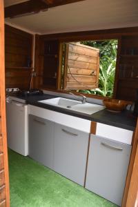 a kitchen with a sink and a window at Gite du Manial Tipi bois Danse du Soleil in Pointe-Noire
