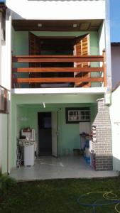 a house with a balcony and a patio at Aconchego in Paraty