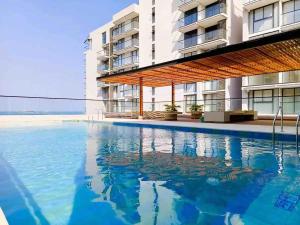 a swimming pool in front of a building at Amazing 2BR Apartament with pool in Santa Marta in Santa Marta +7 photos