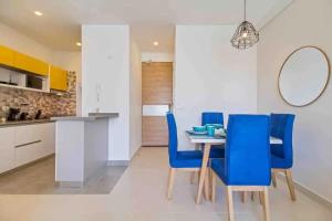 a dining room with a table and blue chairs at Amazing 2BR Apartament with pool in Santa Marta in Santa Marta