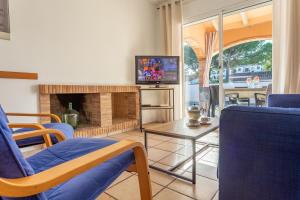 un salon avec une télévision et une cheminée dans l'établissement Casa Merce, à L'Escala 20 autres photos
